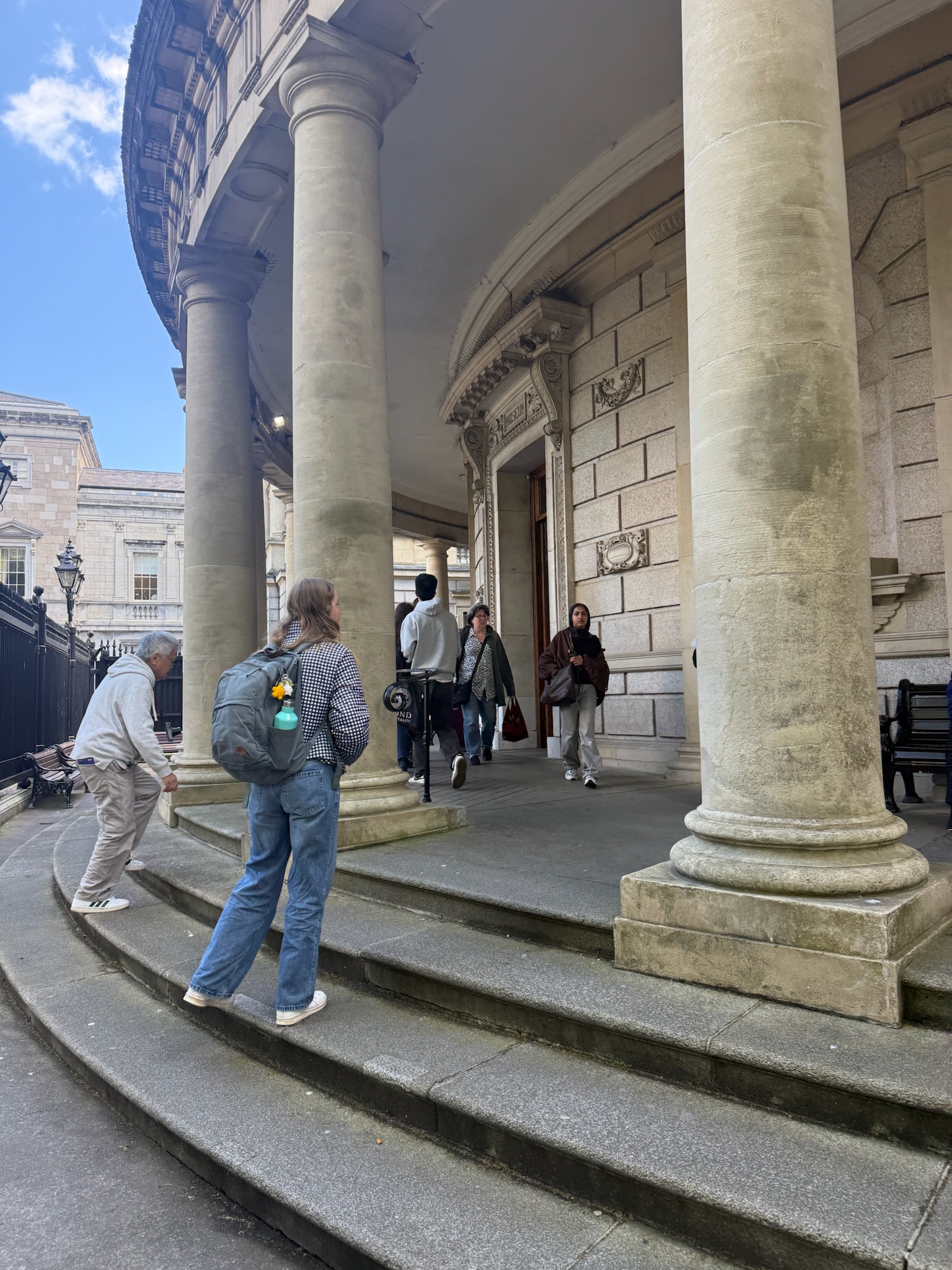 View of the outside of museum, seen as tall circular building with people walking in the front